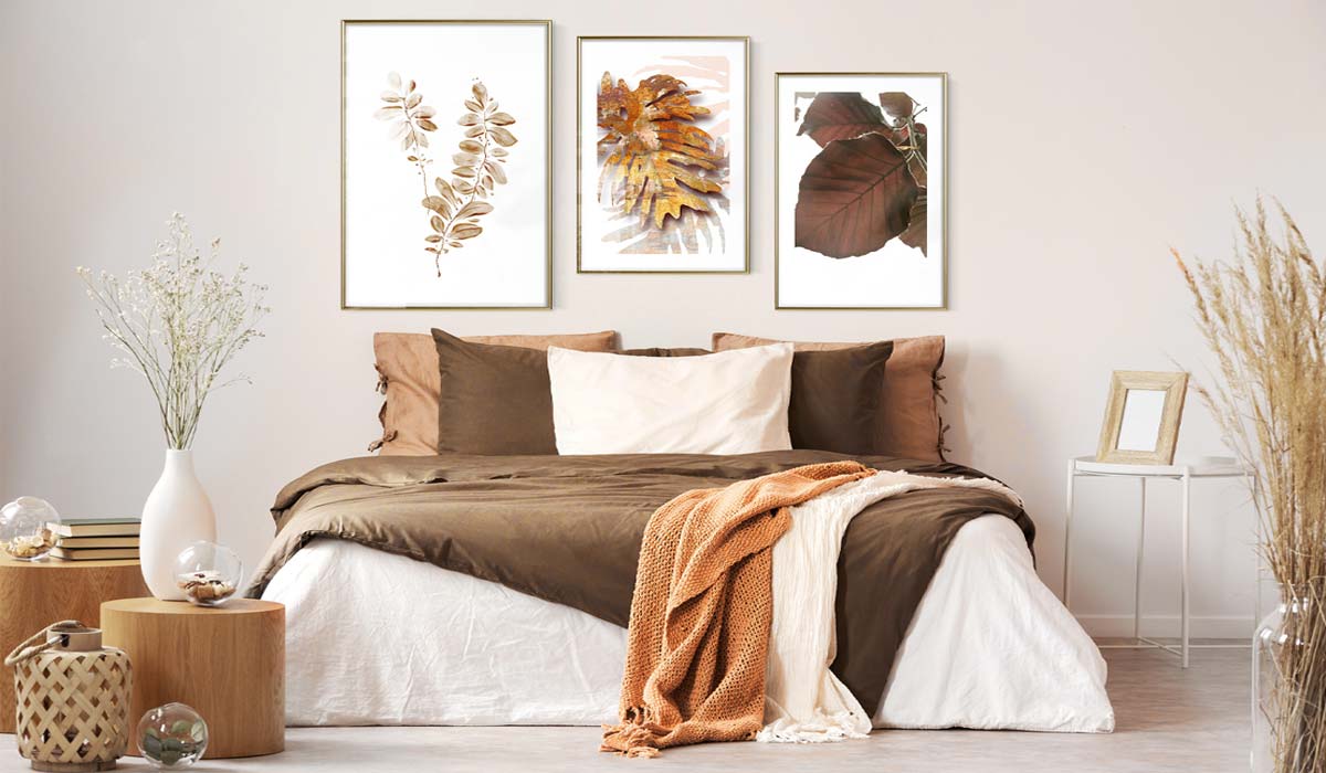 Chambre élégante avec lit aux tons bruns et tableaux botaniques décoratifs sur le mur