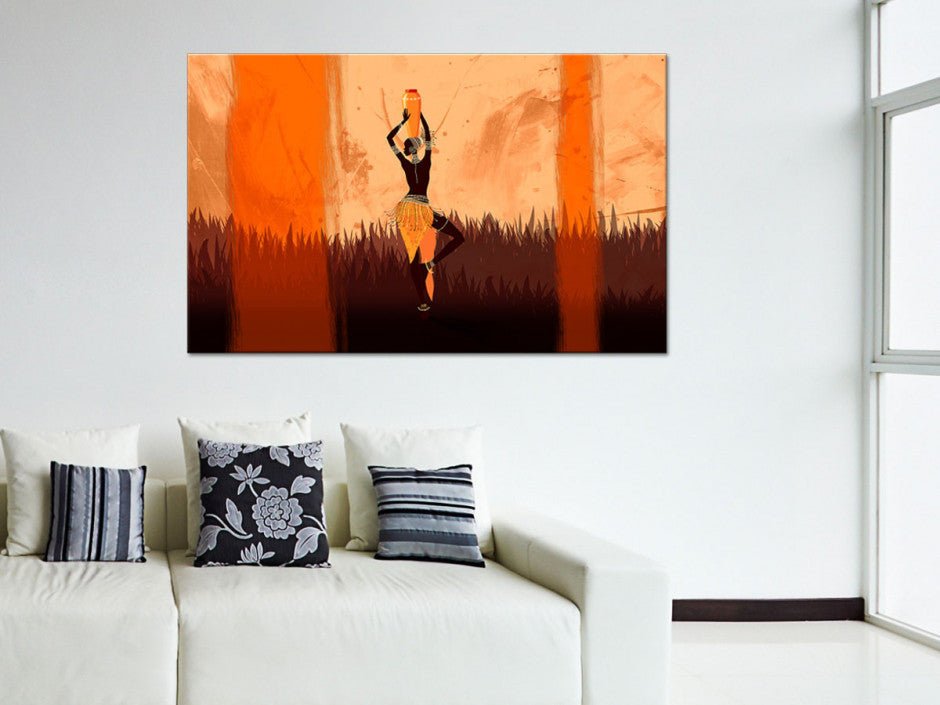 Peinture moderne avec une silhouette dans des tons orange sur un mur au-dessus d'un canapé blanc