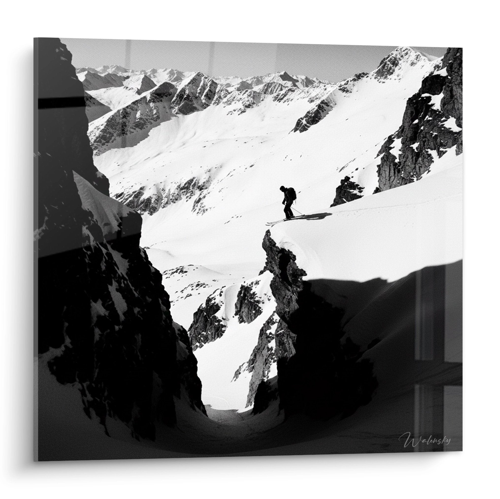 Tableau noir et blanc montrant skieur solitaire sur pentes enneigees entourees de sommets rocheux alpins