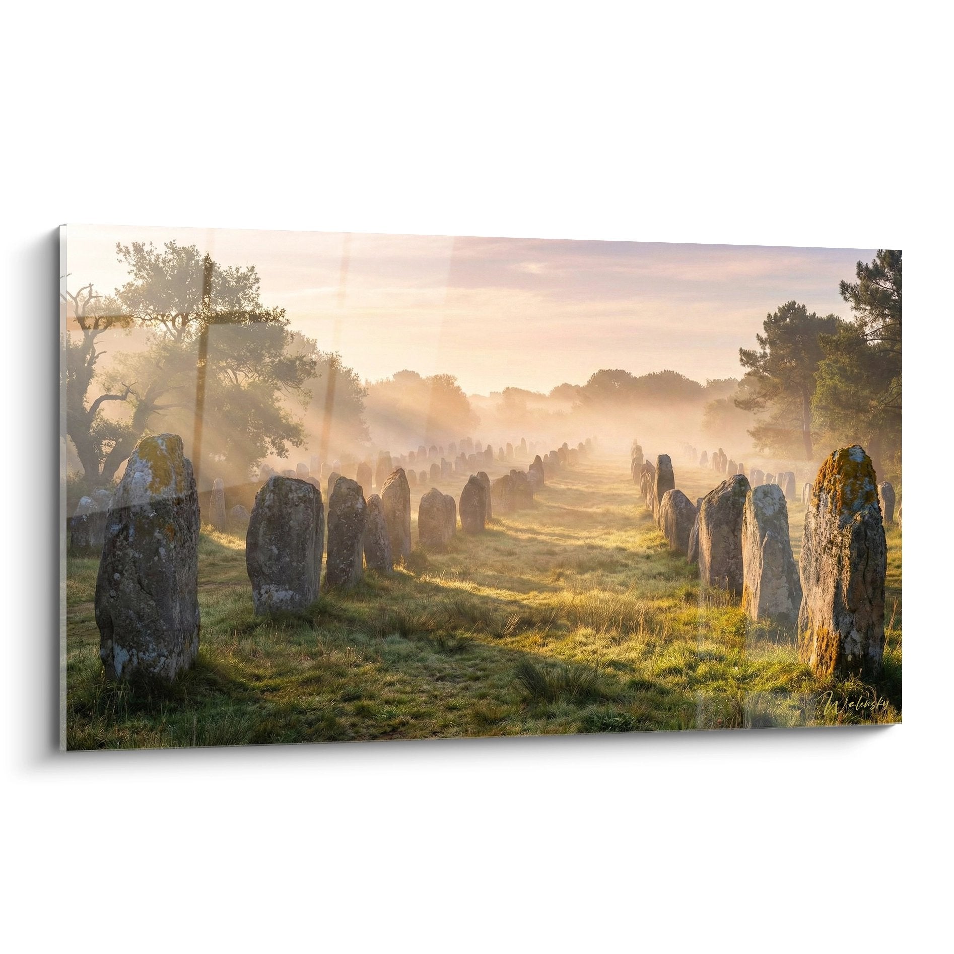Carnac stone alignments in golden morning mist with mysterious menhirs in Brittany