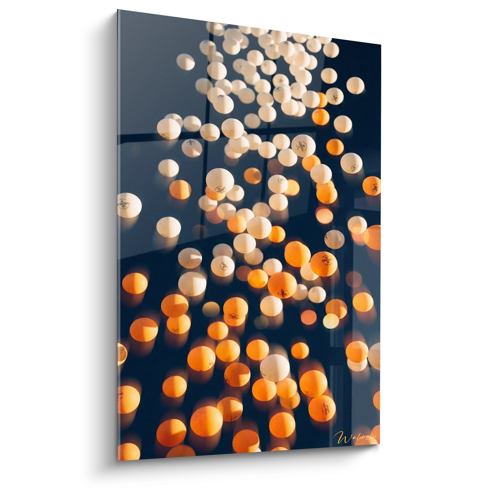 Tableau artistique avec balles de ping-pong blanches et orange illuminées sur fond sombre