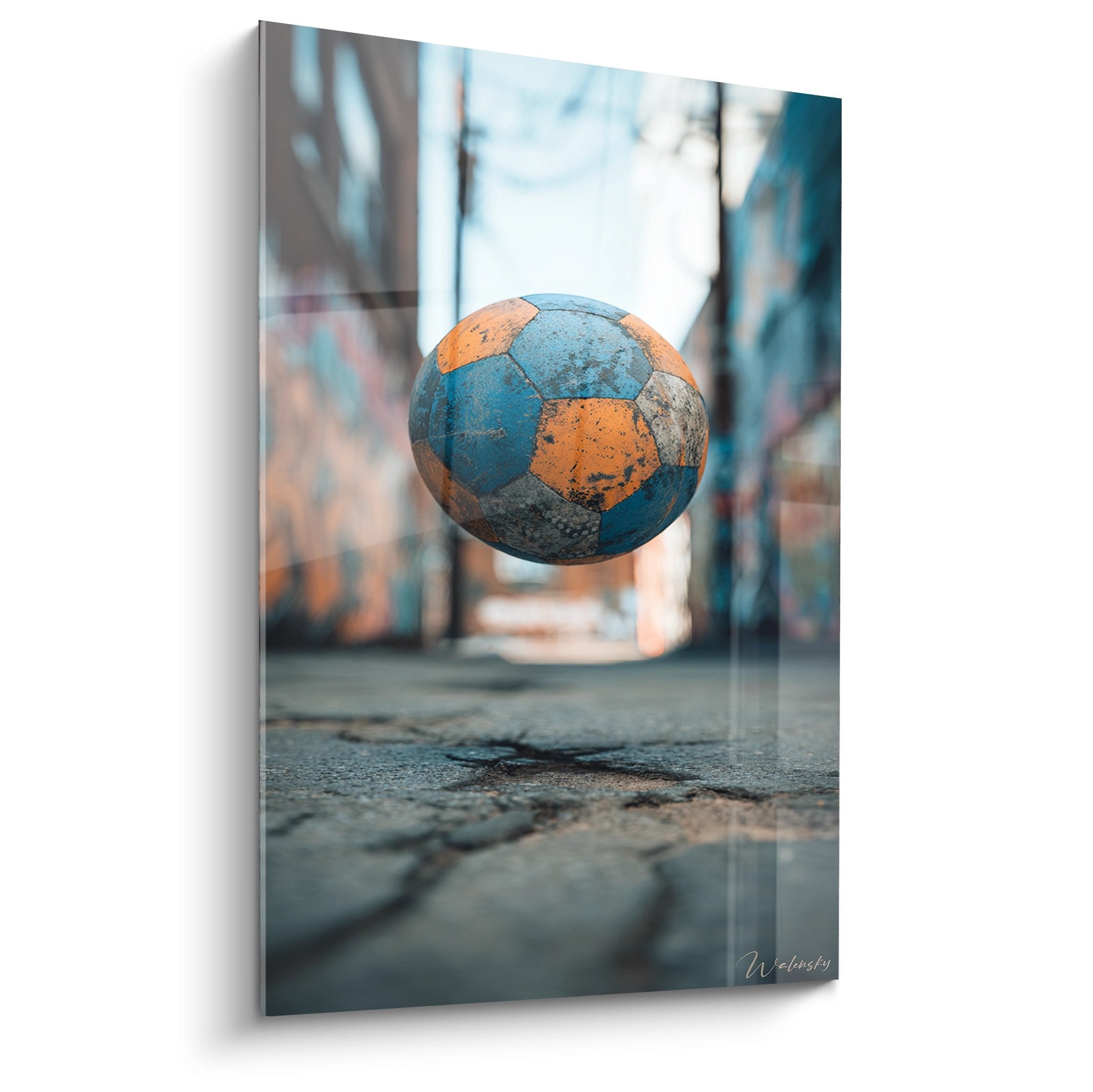 Tableau football urbain avec ballon en lévitation dans rue, couleurs bleu orange, décoration sport moderne