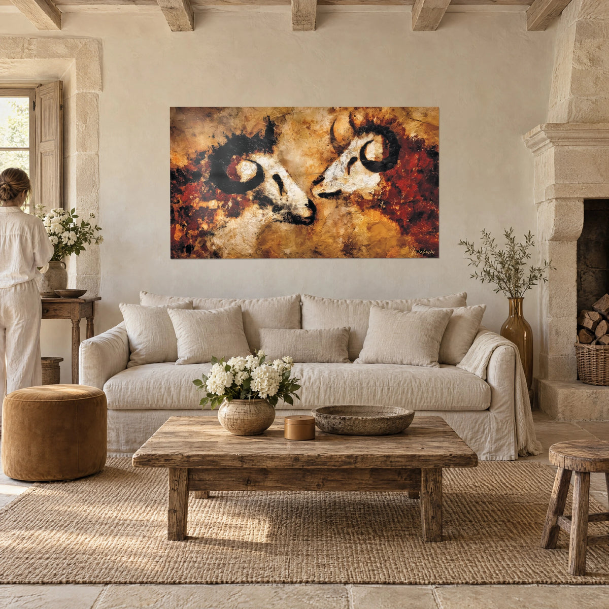 Schilderij twee stieren oog in oog met zwarte spiraalvormige hoorns, goudocker en bloedrood, boven een bank in een lichte woonkamer