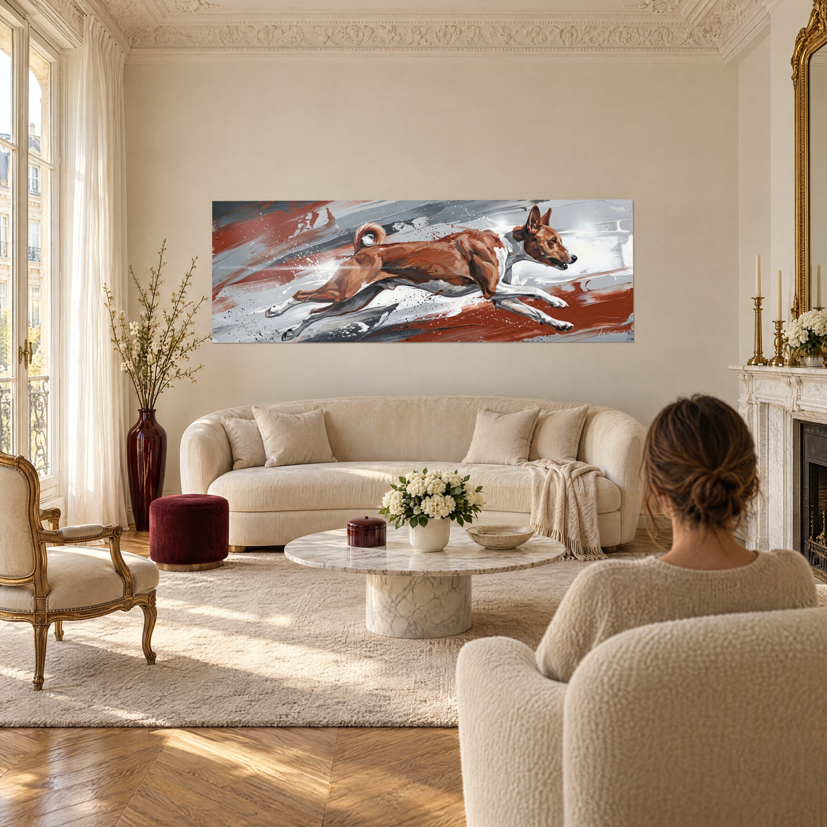 Tableau lévrier basenji bondissant, pelage roux et blanc sur coulures grises, au-dessus d'un canapé dans un salon lumineux