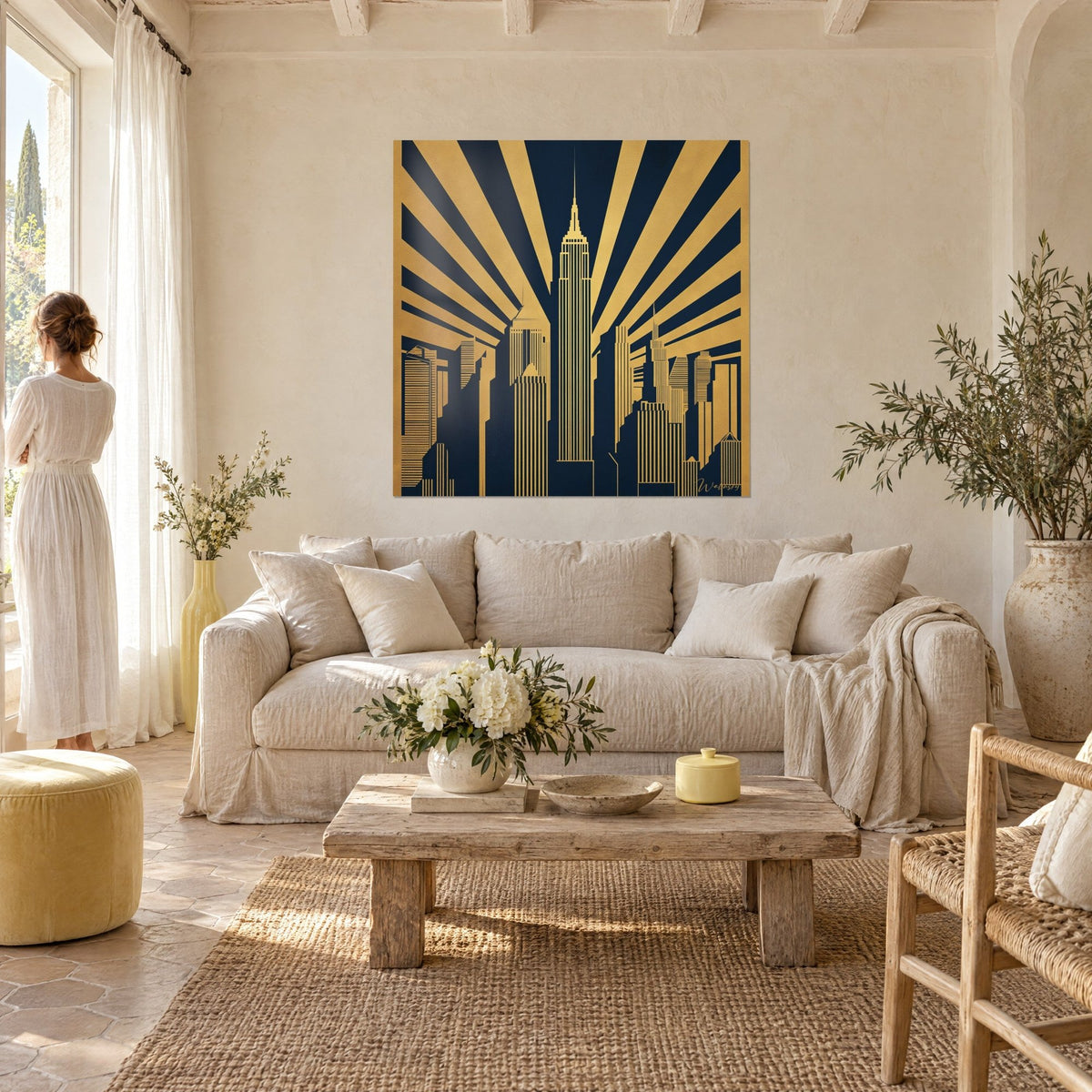 Πίνακας ουρανοξύστες Art Deco με χρυσές ακτίνες σε σκούρο μπλε φόντο, δύο πίσω όψεις σιλουετών πάνω από ένα καναπέ σε φωτεινό σαλόνι