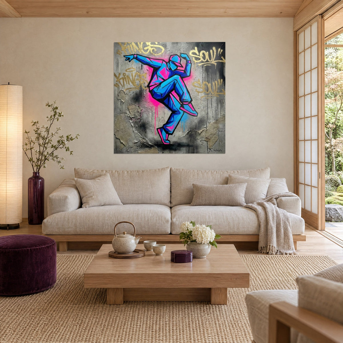 Gemälde Hip-Hop-Tänzer in elektrischem Blau und Neonrosa, goldene Graffiti auf Beton, über einem Sofa in einem hellen Wohnzimmer