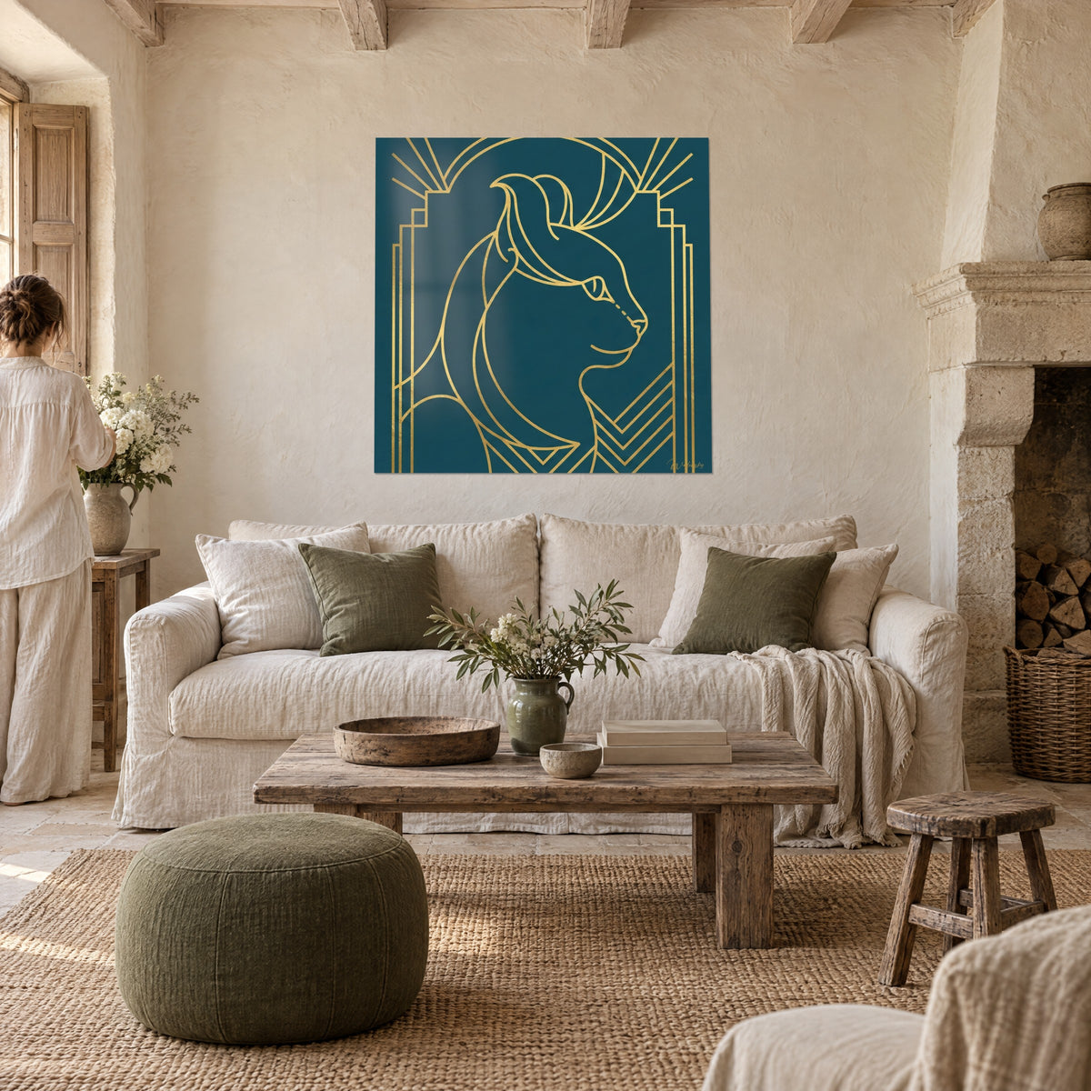 Πίνακας Art Deco γάτα με χρυσές γραμμές σε πετρόλ φόντο, σγουρά αυτιά, δύο άτομα από πίσω, πάνω από καναπέ σε φωτεινό σαλόνι