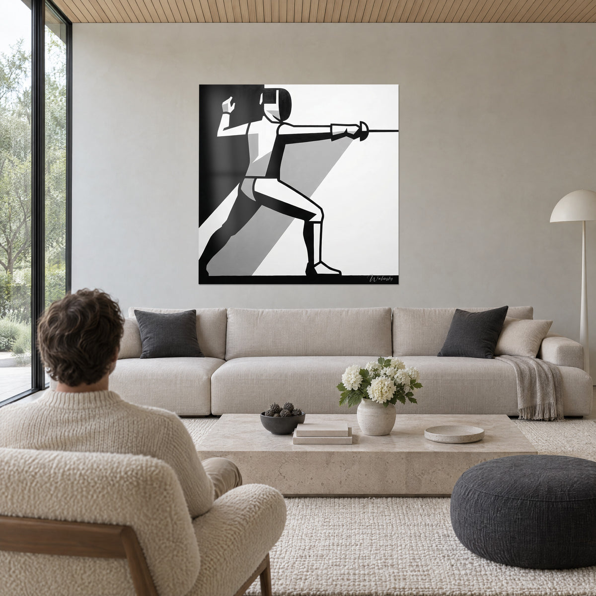 Tableau escrimeur en pleine fente, bras armé tendu, aplats noirs et gris sur fond blanc, au-dessus d'un canapé dans un salon lumineux