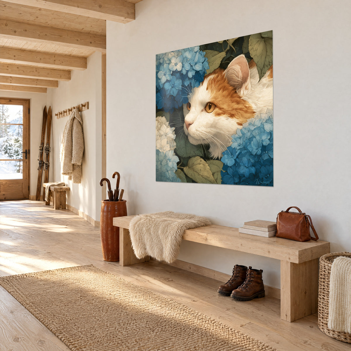 Tableau félin crème à taches orangées entouré d'hortensias azur et de feuilles vert sauge, mur blanc d'une entrée de chalet