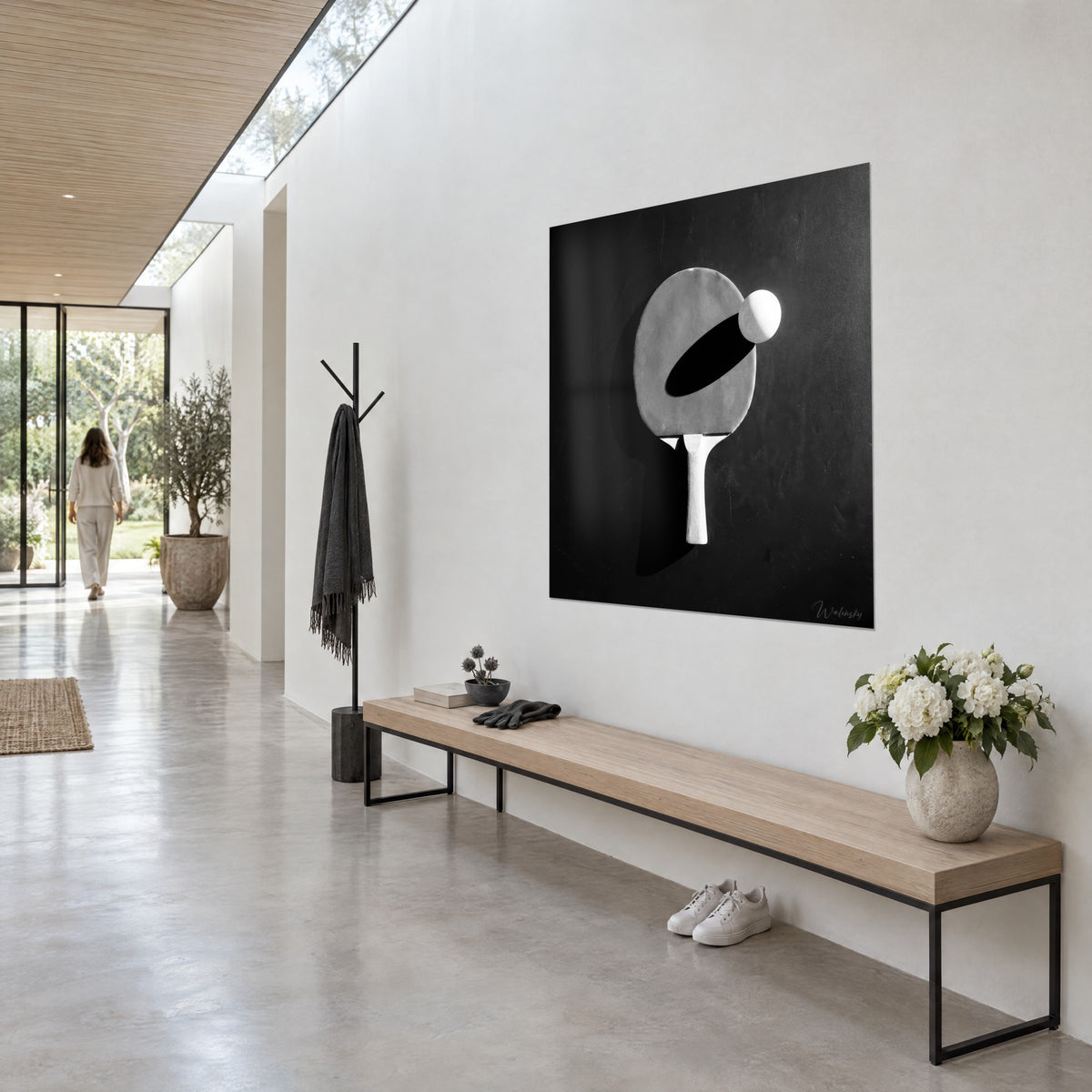 Πίνακας με λευκή μπάλα ping-pong που αιωρείται πάνω από γκρι ρακέτα, οβάλ μαύρη σκιά, ασπρόμαυρο, σε αρχιτεκτονικό διάδρομο