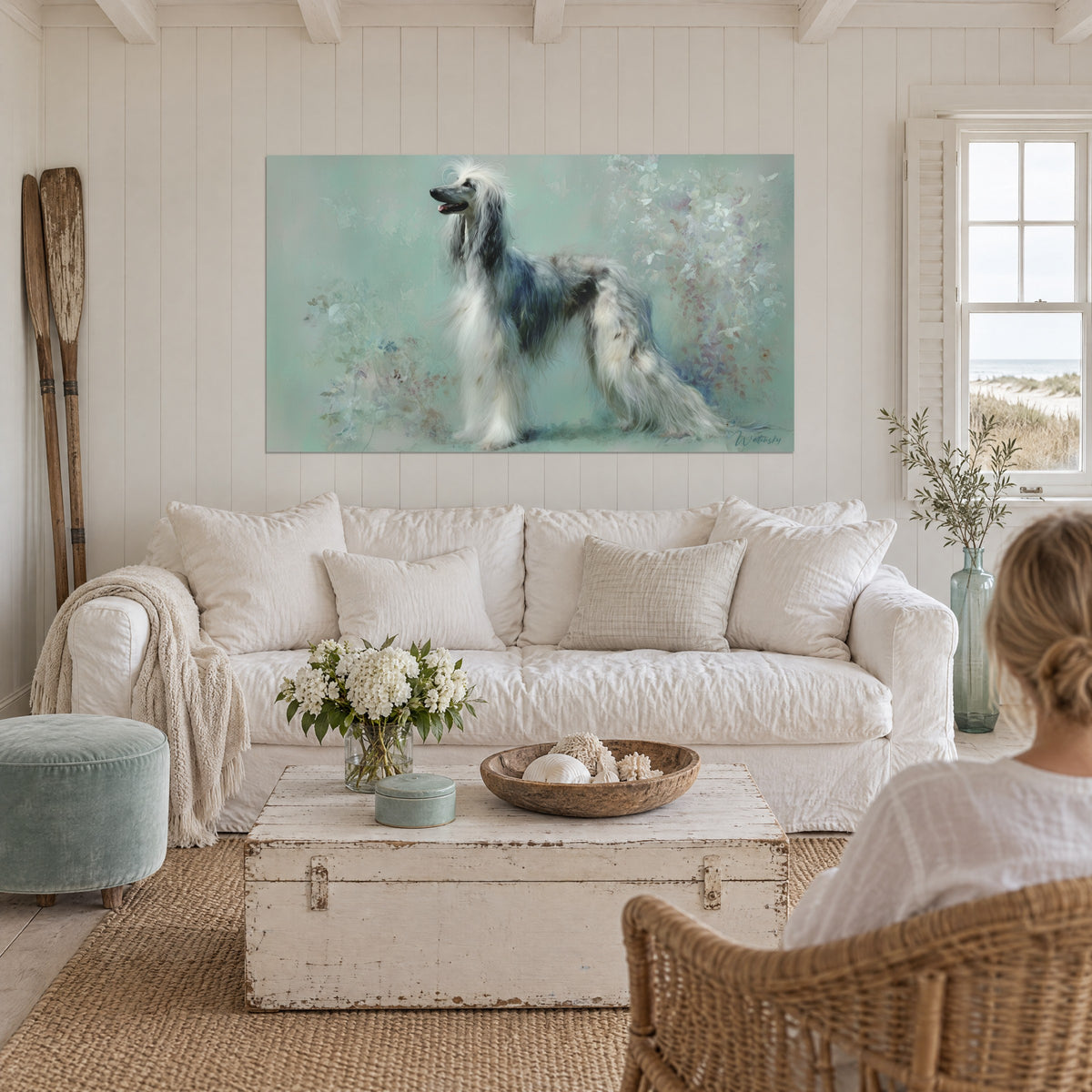 Wall art of a white and grey Afghan hound with flowing mane on a sea-green background, above a sofa in a bright living room