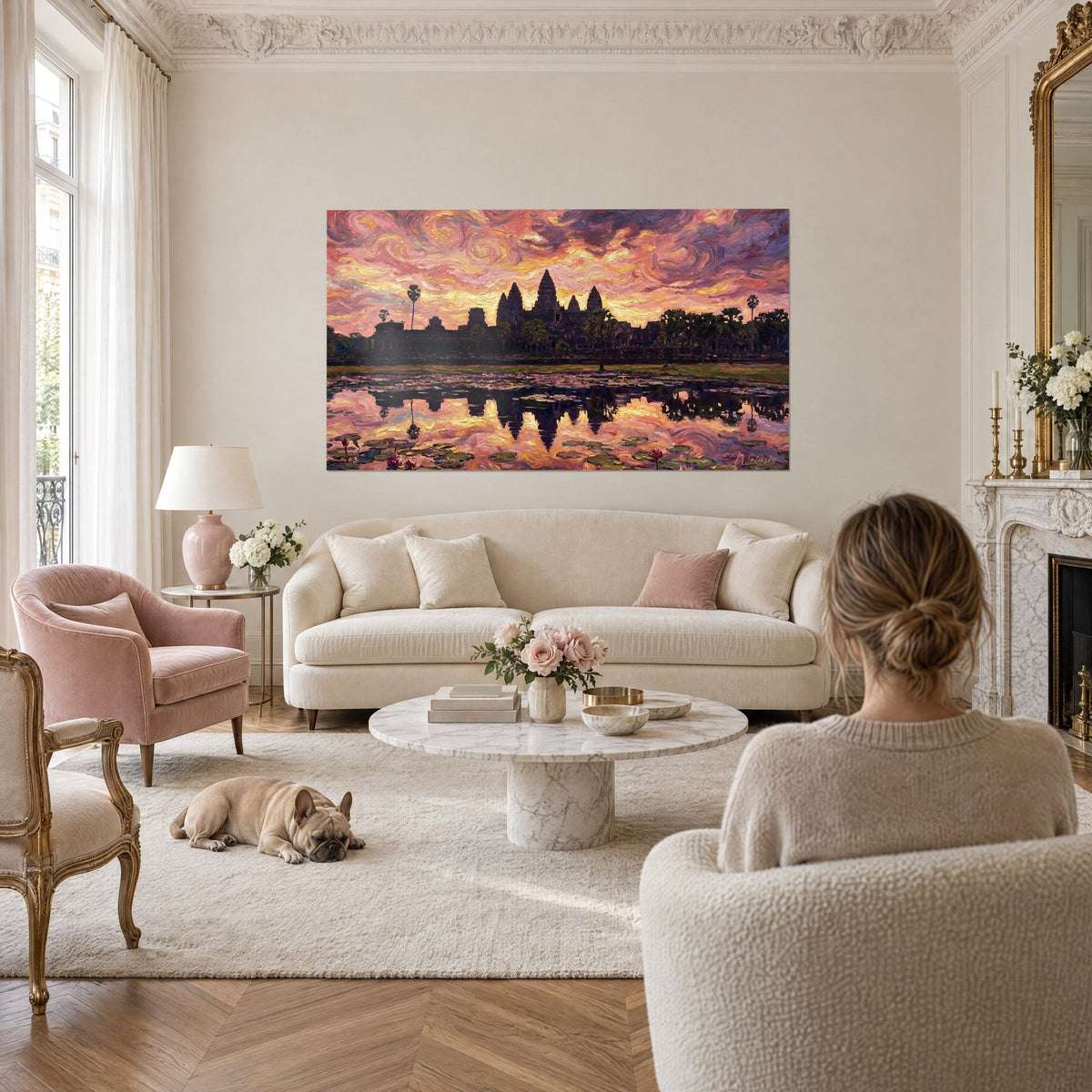 Cuadro silueta de Angkor Wat bajo un cielo rosa y naranja arremolinado, reflejos dorados, encima de un sofá en un salón luminoso