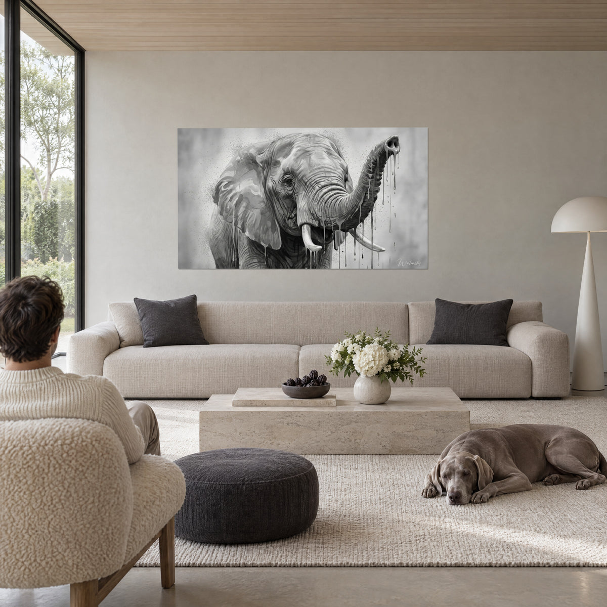 Tableau éléphant d'Afrique en noir et blanc, trompe dressée et coulures grises, au-dessus d'un canapé dans un salon lumineux