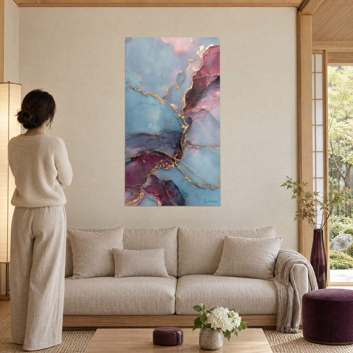 Quadro marmo astratto azzurro cielo venato d'oro e bordeaux, donna di spalle, sopra un divano in un soggiorno luminoso