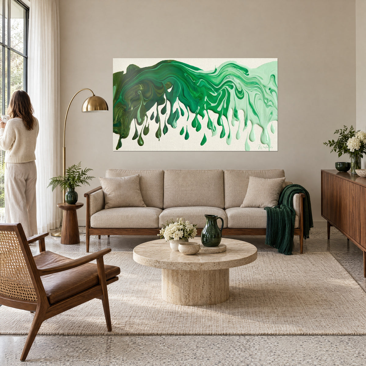 Schilderij met smaragdgroene en mintgroene verfdruipingen op ongebleekt canvas, neerhangende druppels, vrouw van achteren, boven een bank in een lichte woonkamer