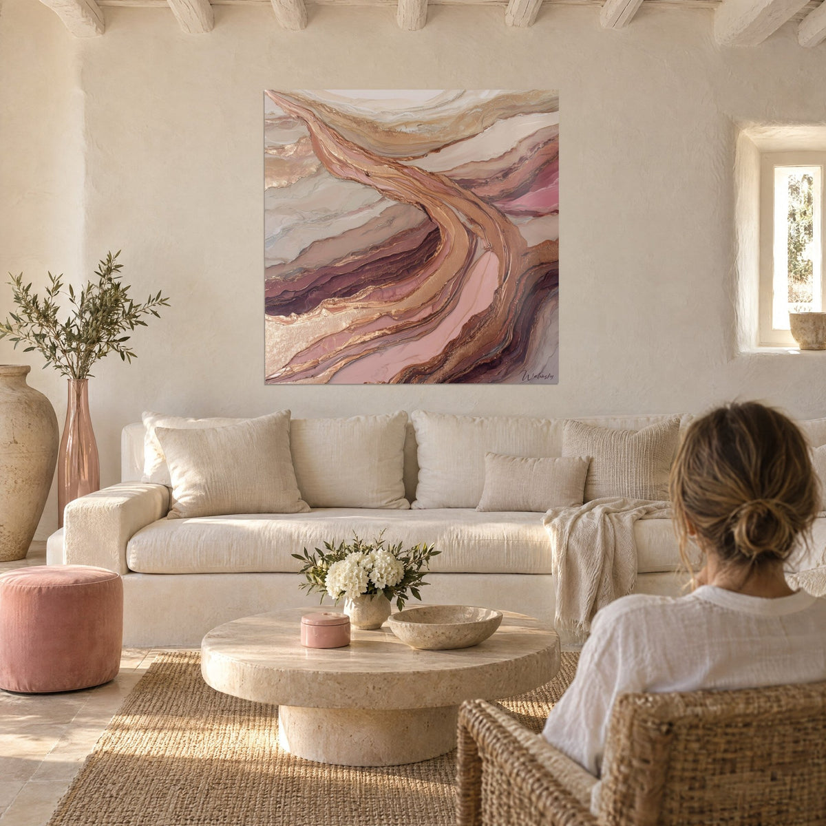 Cuadro de estratos minerales rosa polvo y cobre dorado, cinta metálica curvada, sobre un sofá en un salón luminoso