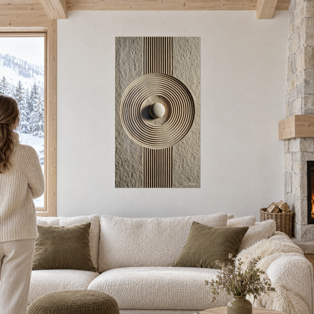 Quadro giardino zen di sabbia ocra con cerchi incisi, ciottolo crema al centro, sopra un divano in un soggiorno luminoso