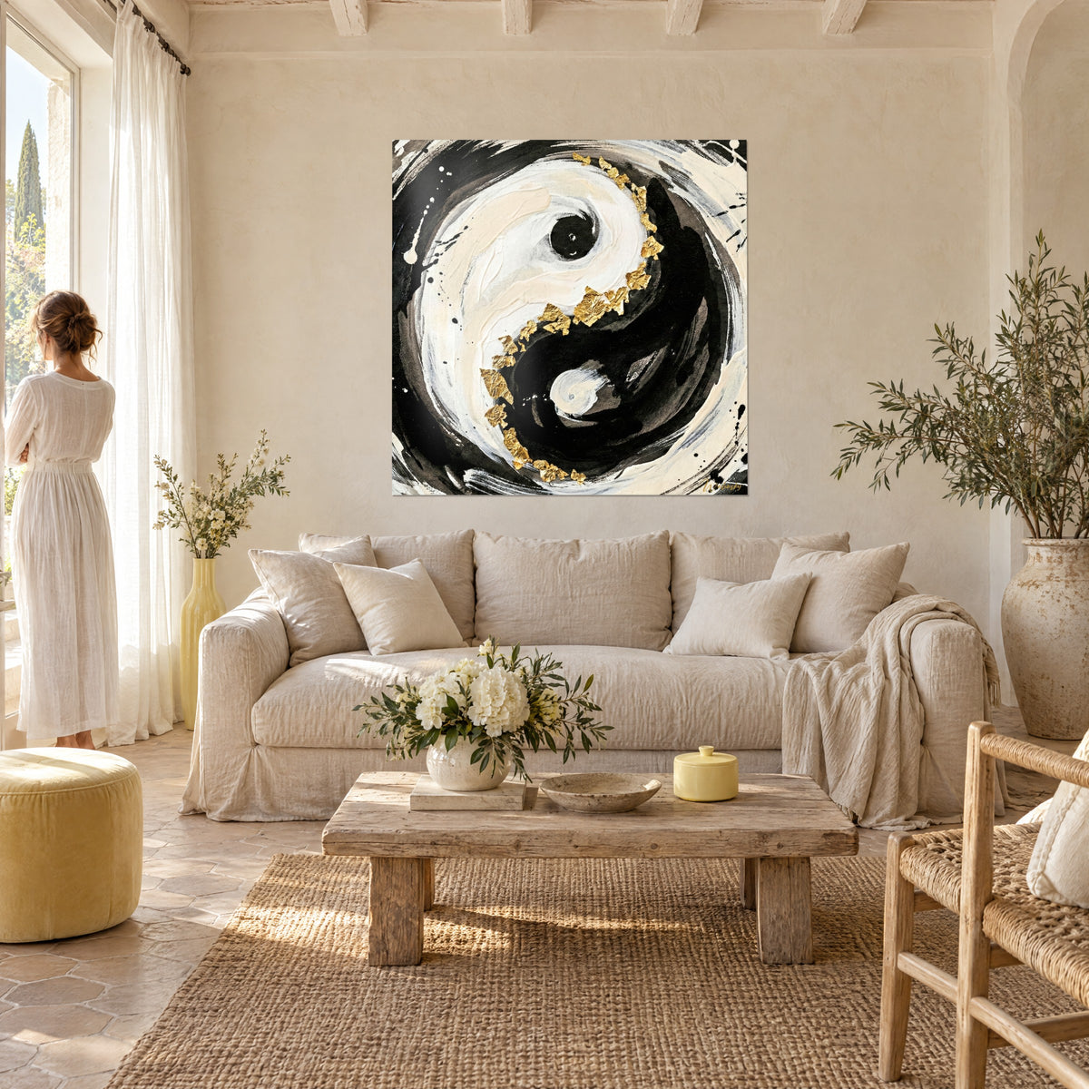 Πίνακας με σύμβολο yin yang σε μαύρο και κρεμ λευκό, φύλλα χρυσού στη σπείρα, γυναίκα από πίσω πάνω από έναν καναπέ σε φωτεινό σαλόνι