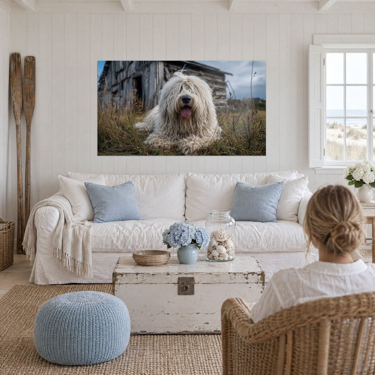 Πίνακας Komondor με μακριές κρεμ κλωστές, ροζ γλώσσα, ξαπλωμένος στο χρυσό γρασίδι, πάνω από καναπέ σε φωτεινό σαλόνι