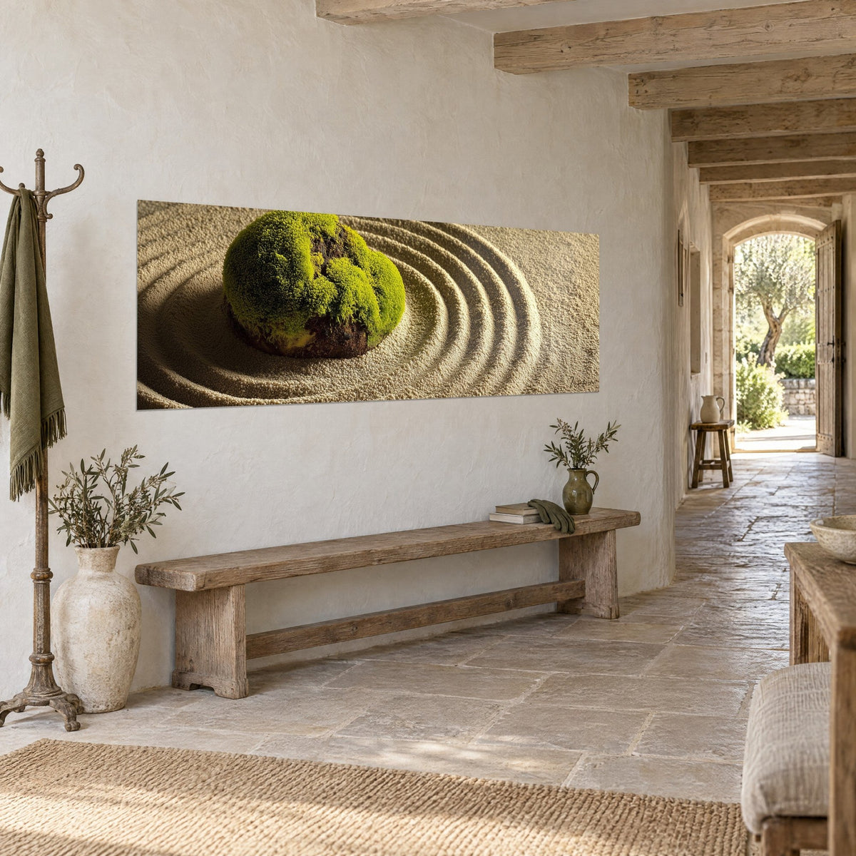 Tableau galet moussu émeraude entouré d'ondulations de sable beige, accroché au mur d'une entrée en pierre dallée