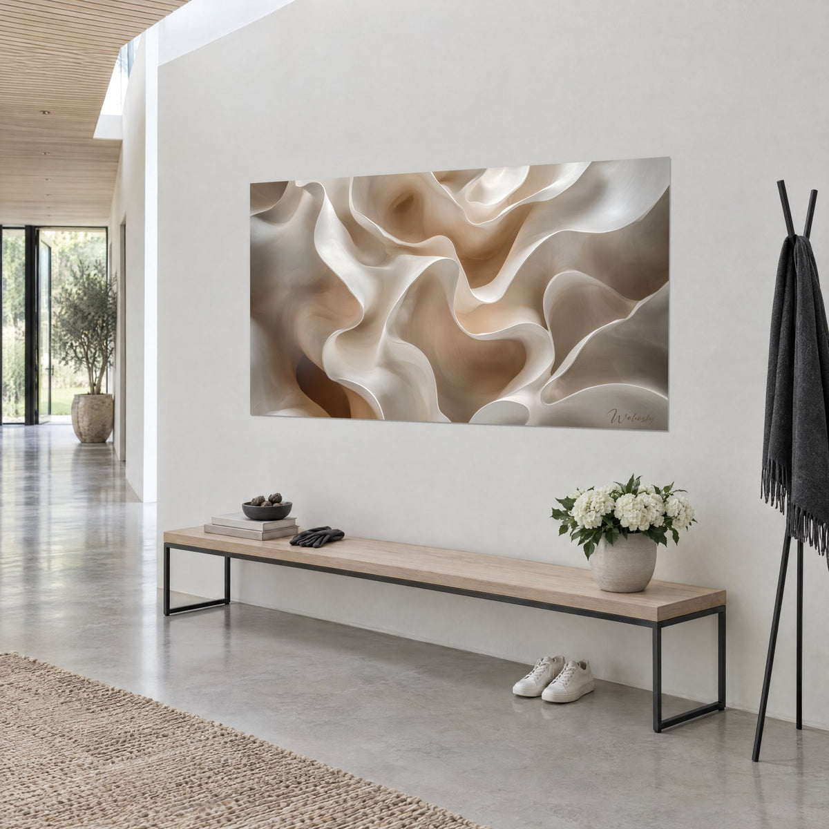 Quadro con petali scolpiti in crema e caramello dai bordi luminosi, appeso sopra una panca in legno in un ingresso chiaro