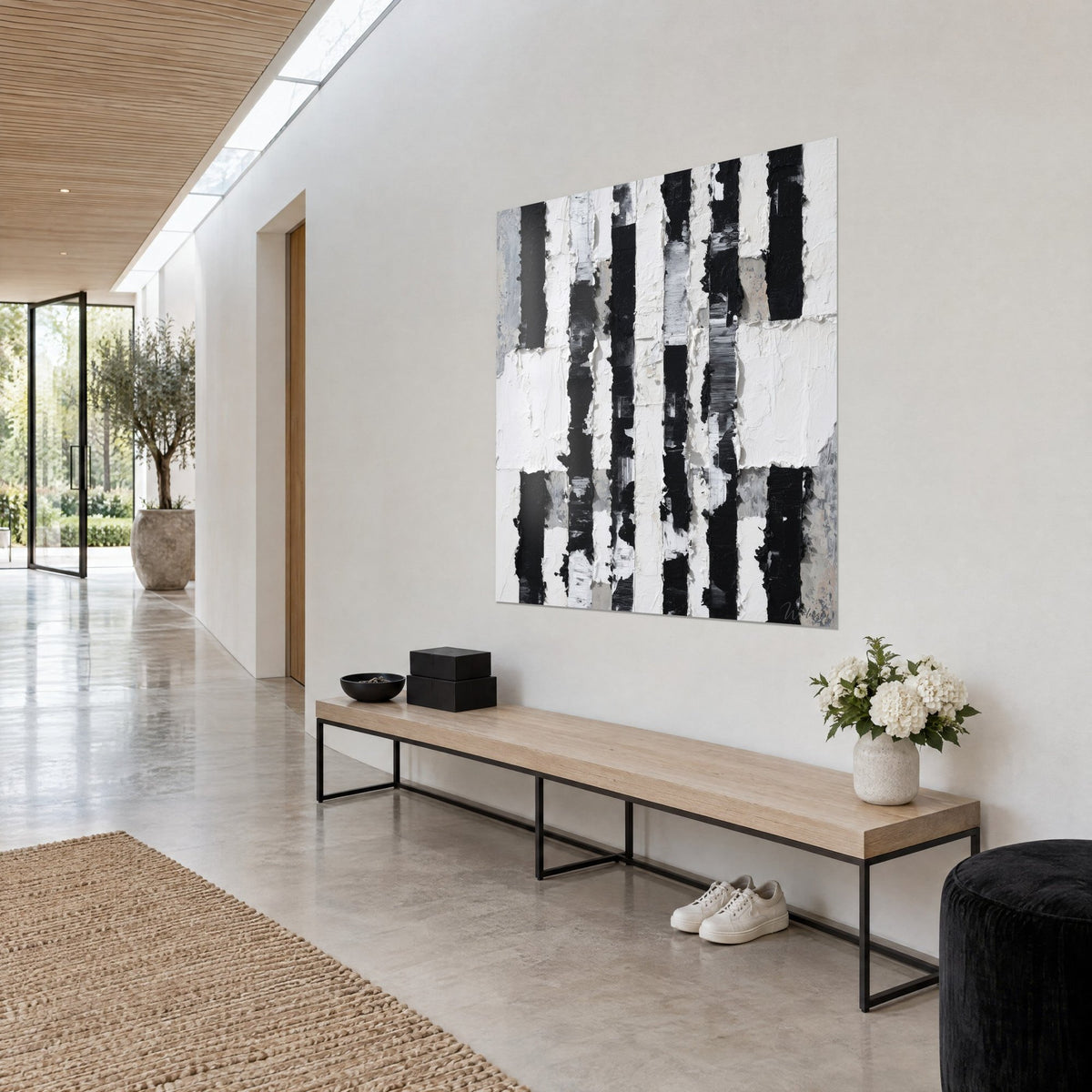 Quadro con segni di inchiostro nero e creste di vernice bianca spessa, grigio pallido, ripreso di tre quarti in un corridoio chiaro