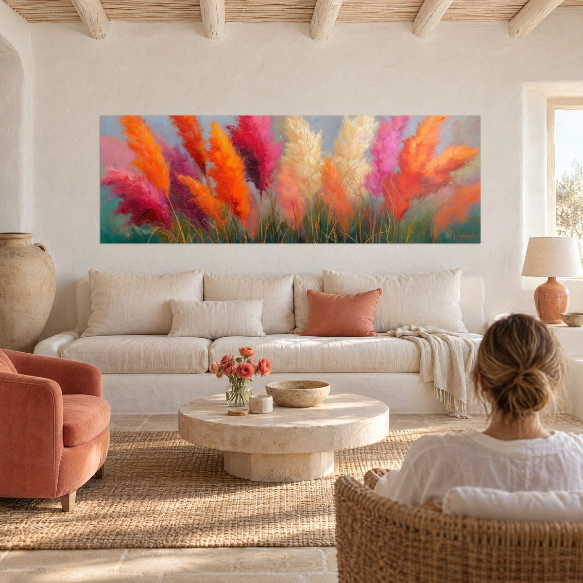 Wall art panoramic pampas grass in orange and fuchsia, cream plumes, sage green background, above a sofa in a bright living room