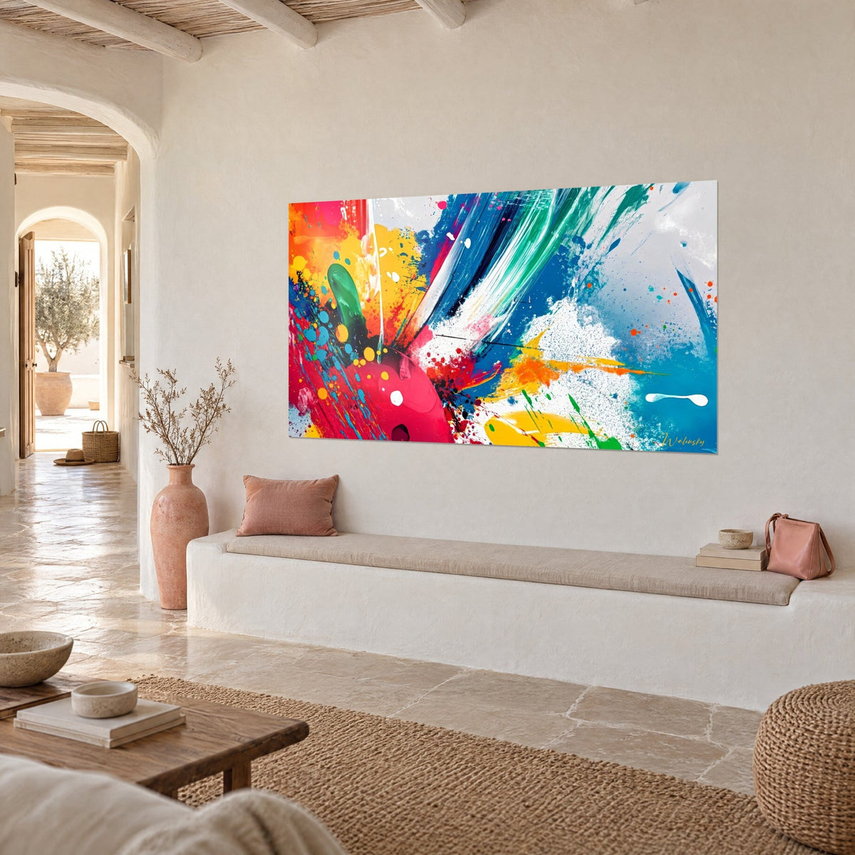 Gemälde mit grünen und blauen Pinselstrichen auf weißem Grund, rosa und orangefarbener Farbklecks als Akzent, schräg aufgenommen in einem mediterranen Haus