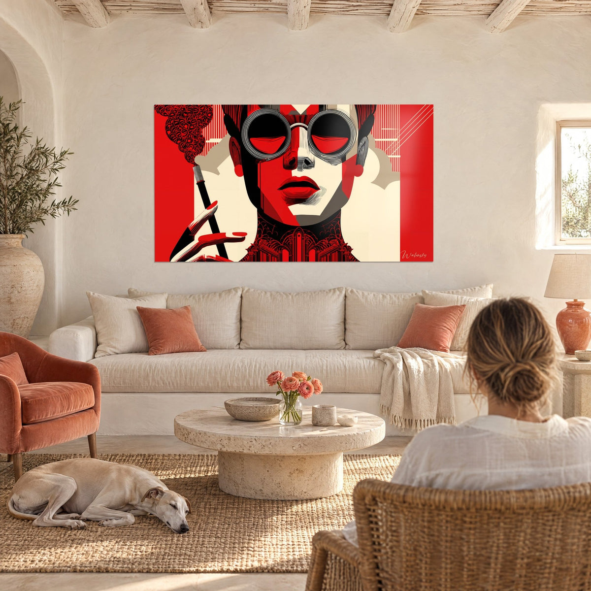 Wall art face with round black glasses, red lips and smoke curling in wisps, on a scarlet and cream background, above a sofa in a bright living room