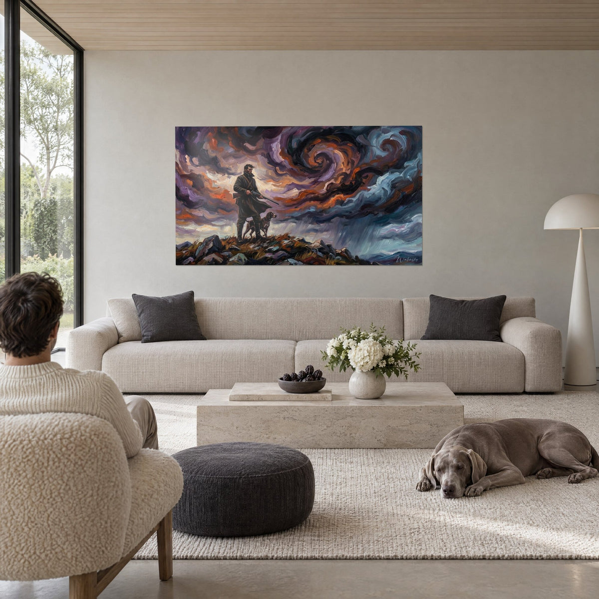 Tableau chasseur en long manteau vert sombre et son chien, ciel orageux violet et orange, au-dessus d'un canapé dans un salon lumineux