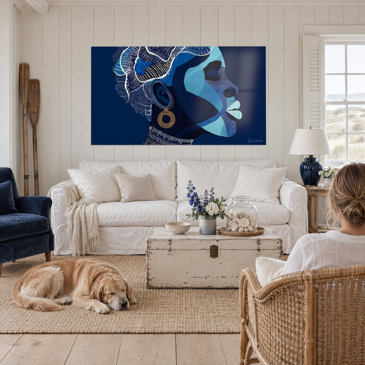 Wall art profile of an African woman in navy and turquoise flat tones, gold earring, above a sofa in a bright living room