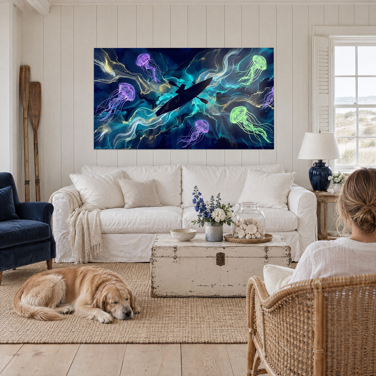 Wall art kayaker in black silhouette surrounded by purple and neon green jellyfish, midnight blue, above a sofa in a bright living room