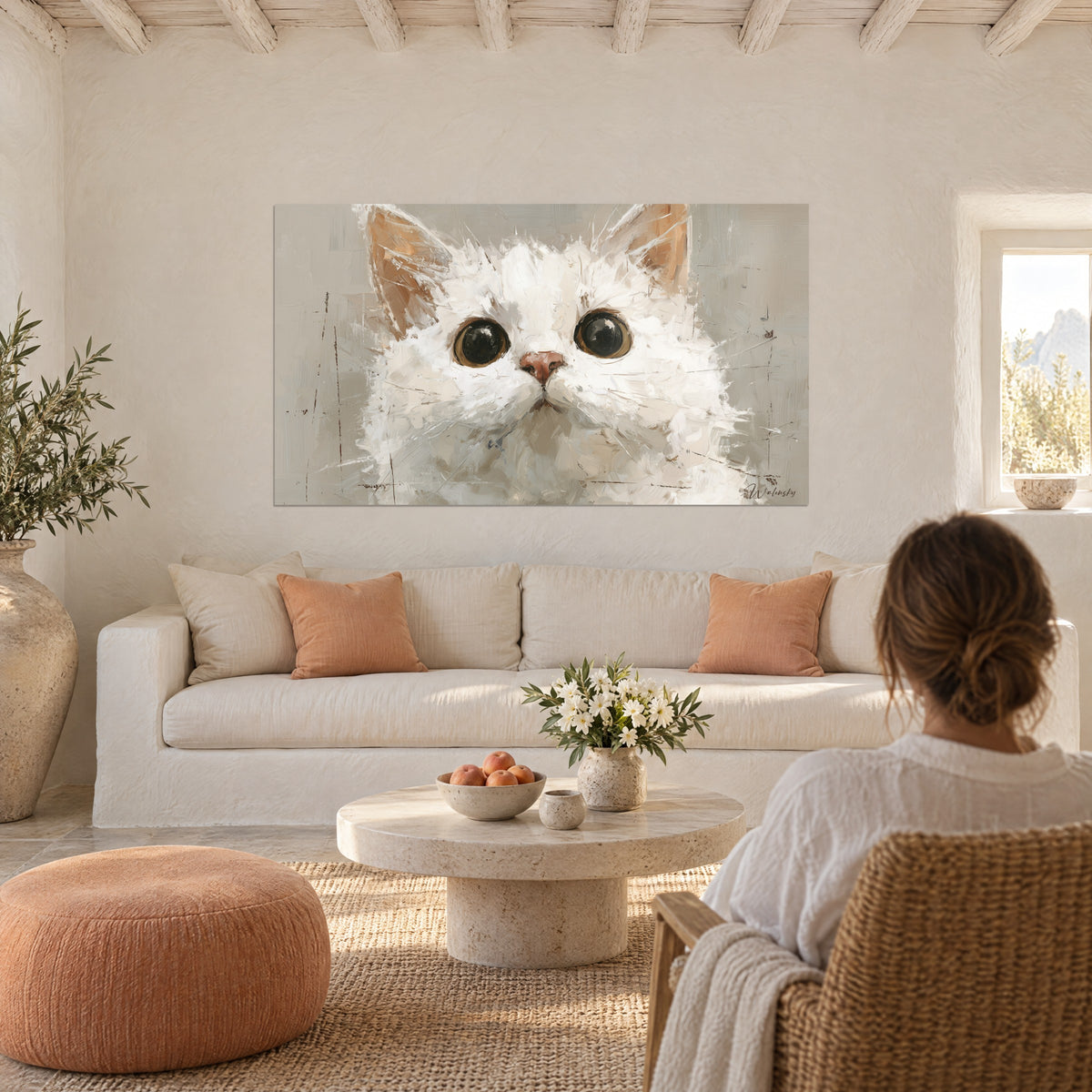 Tableau chaton blanc aux immenses yeux noirs cerclés d'ocre, truffe rose, au-dessus d'un canapé dans un salon lumineux