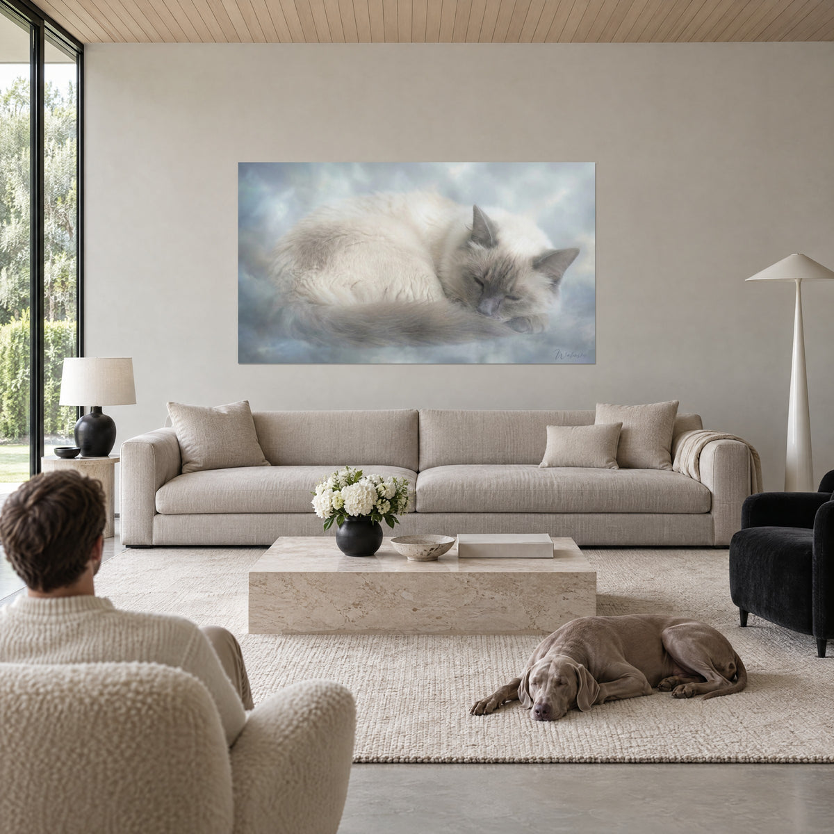 Gemälde Rassekatze zusammengerollt, cremefarbenes Fell und blaugraue Schnauze auf Wolken, über einem Sofa in einem hellen Wohnzimmer