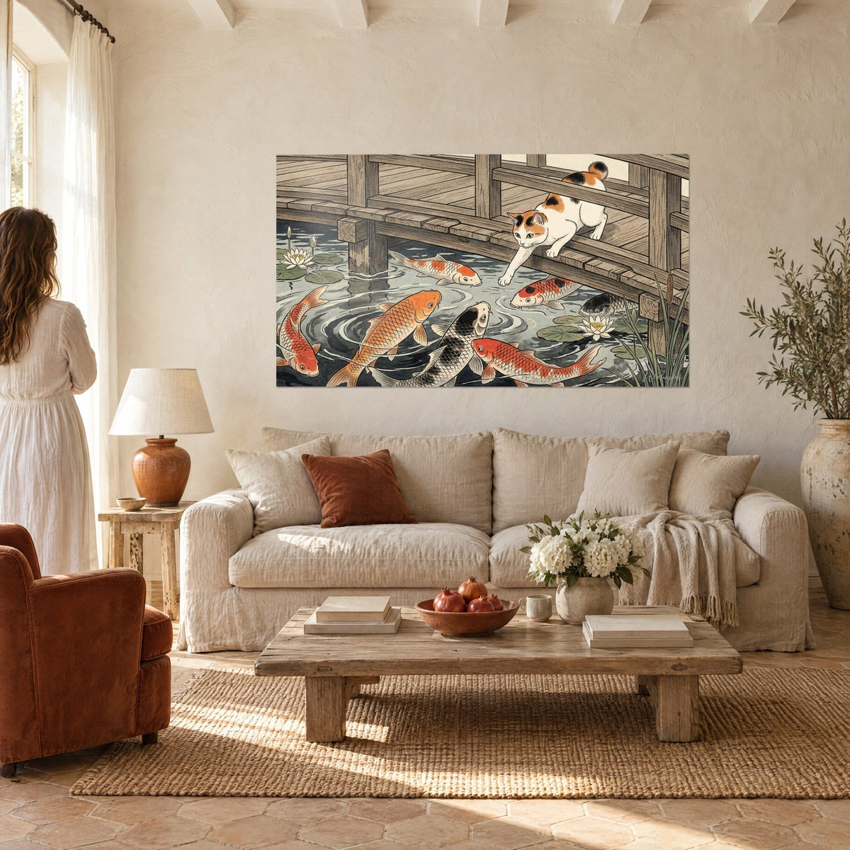 Schilderij kalikokat die over een houten bruggetje leunt boven oranje en zwarte koi-karpers en waterlelies, boven een bank in een lichte woonkamer