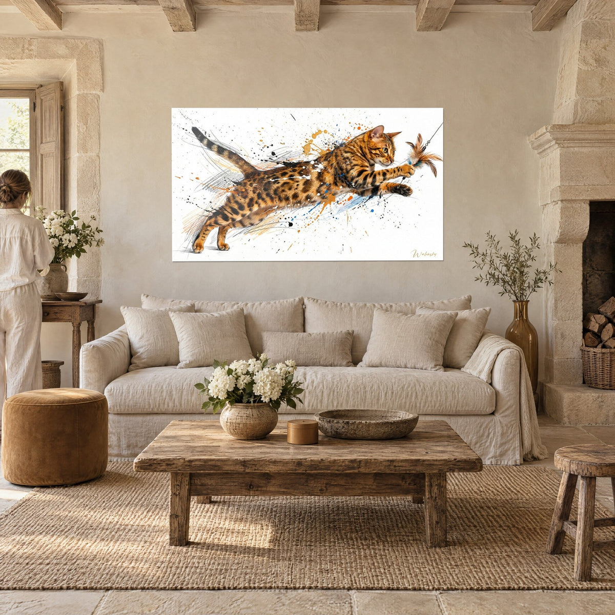 Schilderij springende Bengalkat, oranje vacht met zwarte vlekken en blauwe verfspatten, persoon van achteren boven een bank in een lichte woonkamer