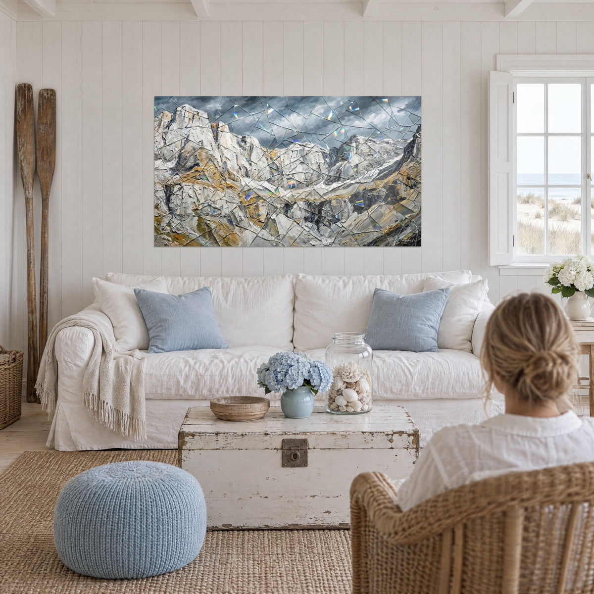 Wall art with a massive rocky mountain in thick grey and ochre impasto, prismatic cracks, above a sofa in a bright living room