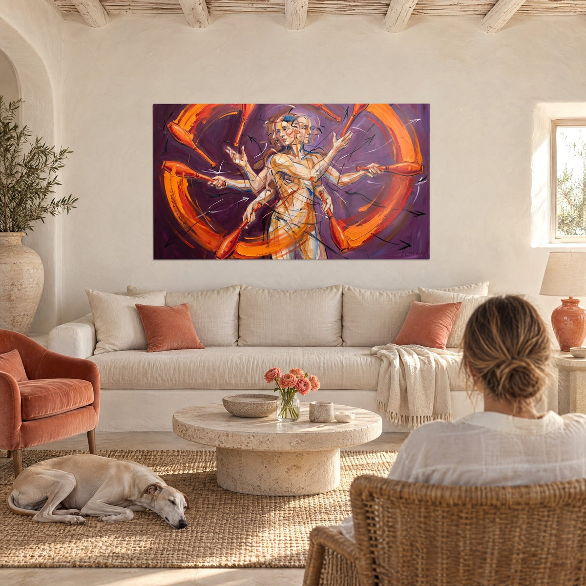 Wall art of a six-armed juggler, orange clubs and deep purple background, a couple seen from behind above a sofa in a bright living room