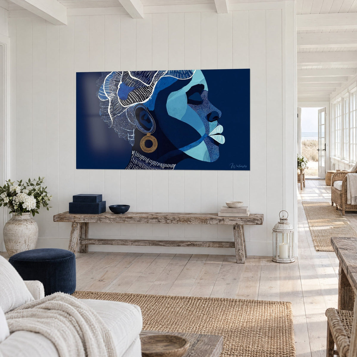 Wall art stylized portrait with white polka dot patterns, headpiece adorned with ivory lines on indigo background, raw wood bench and seaside living room