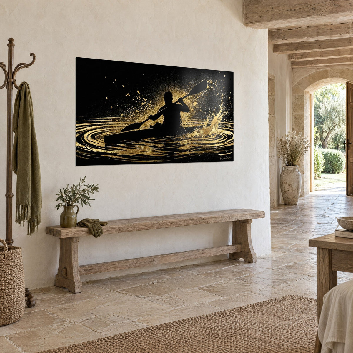 Tableau pagayeur doré fendant des ondes concentriques noir et or, accroché au mur crème d'une maison de pierre, vue de trois-quarts