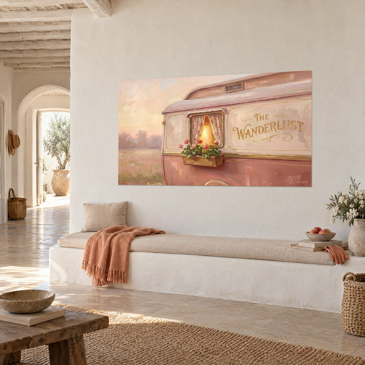 Schilderij oude woonwagen met bloemengordijnen, abrikooskleurige lucht en gouden letters The Wanderlust, witte muur van een stenen huis