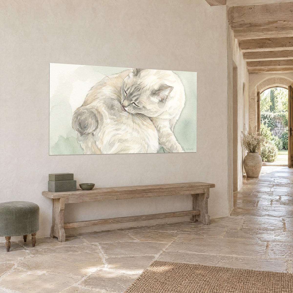 Tableau félin blanc cassé léchant sa patte, taches grises sur le museau, fond vert pâle, mur beige d'une maison en pierre