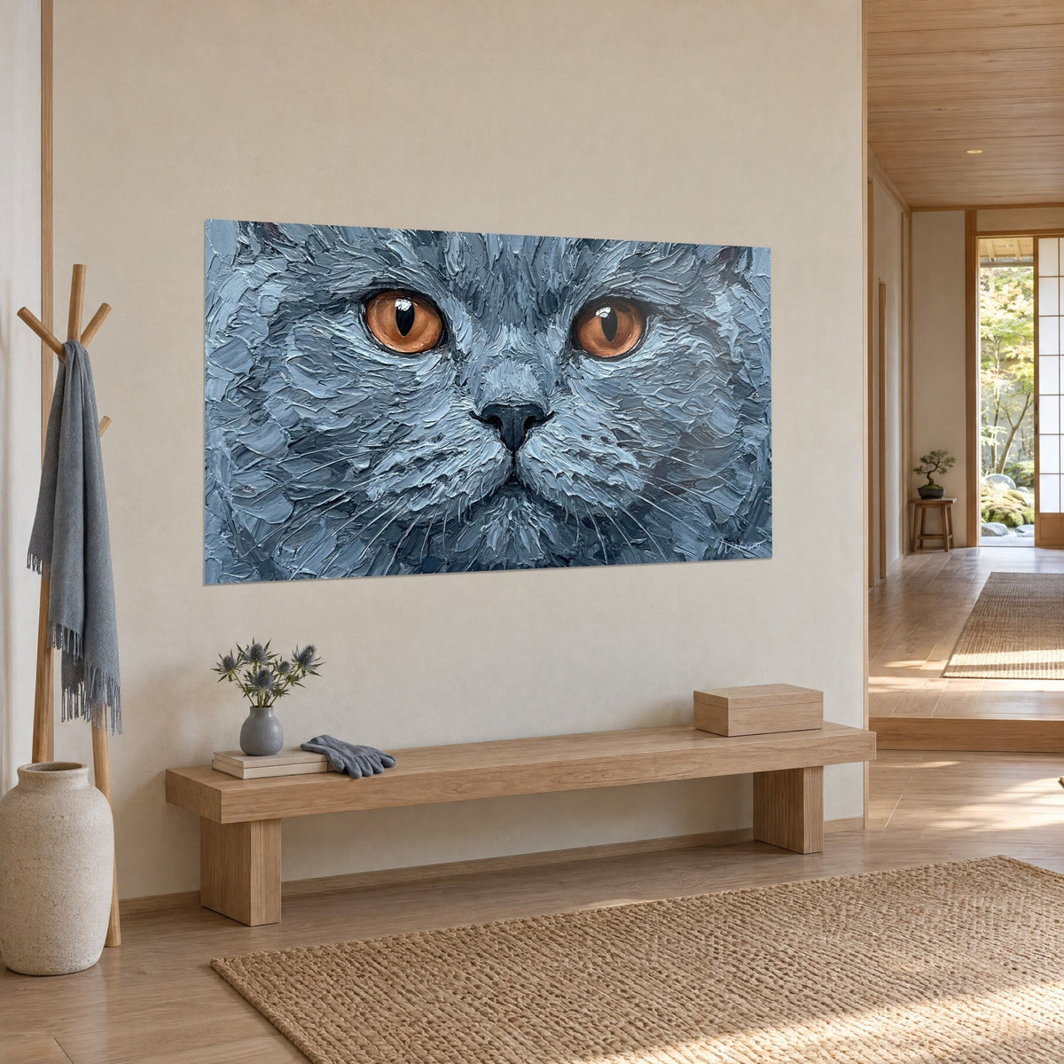 Tableau portrait félin gris ardoise, iris orange cuivré et museau noir, accroché près d'un banc en bois clair et d'une entrée