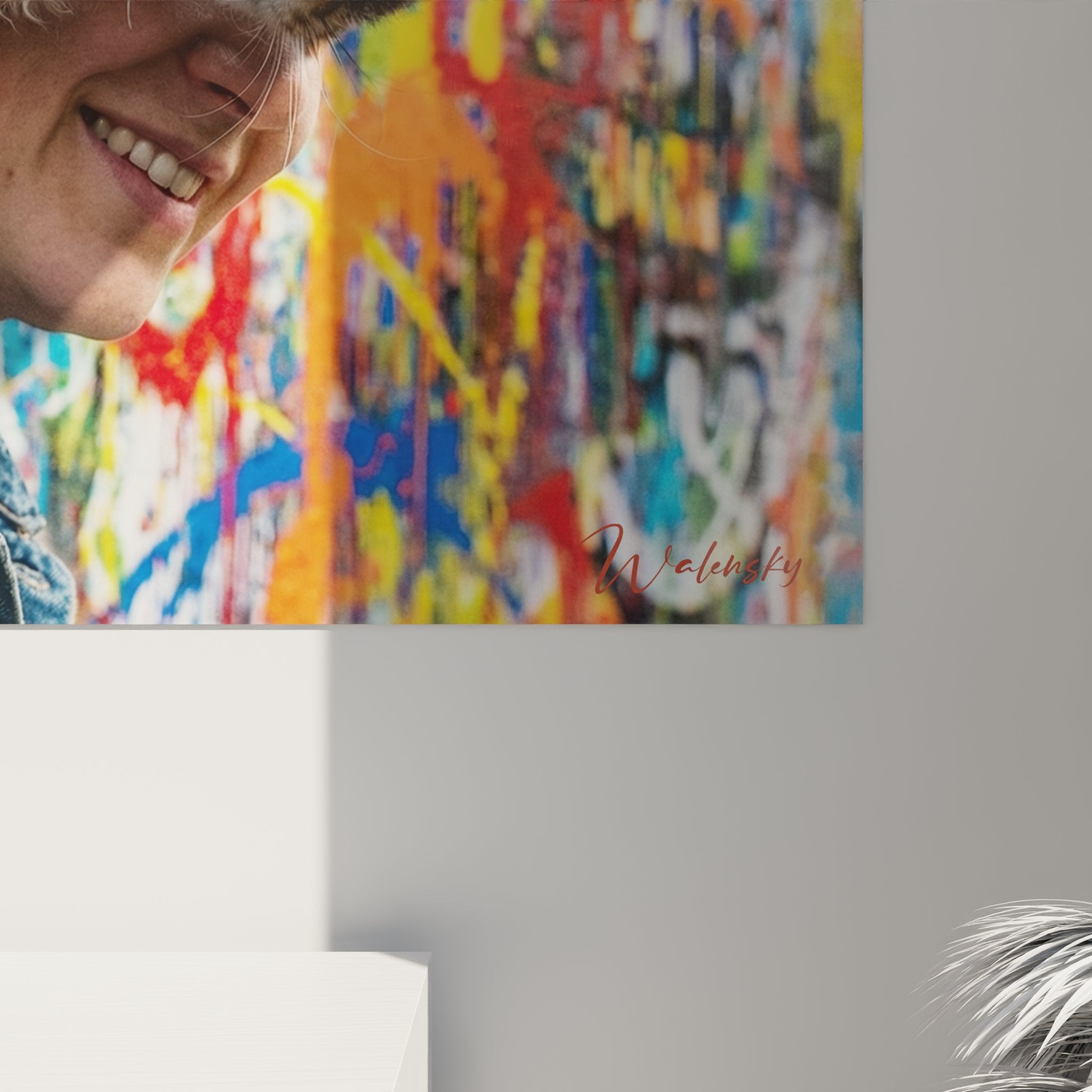 Vista panoramica del quadro decorativo gatto Laperm e proprietario sorridente davanti a un murale urbano multicolore