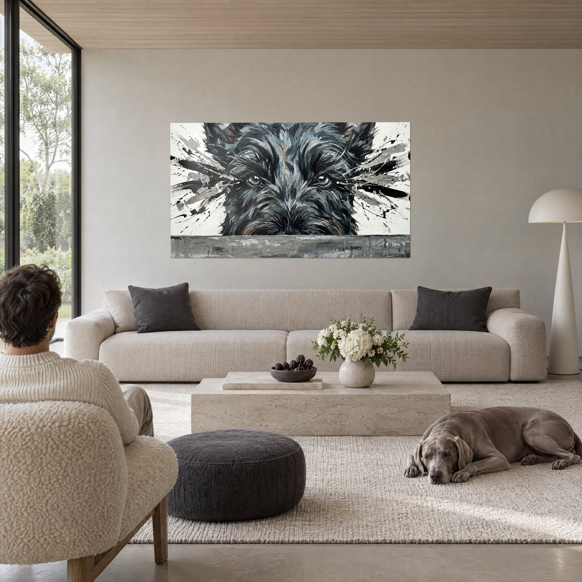 Cuadro de terrier en negro y gris salpicado de gotas de pintura, hocico cobrizo, mirada penetrante, sobre un sofá en un salón luminoso