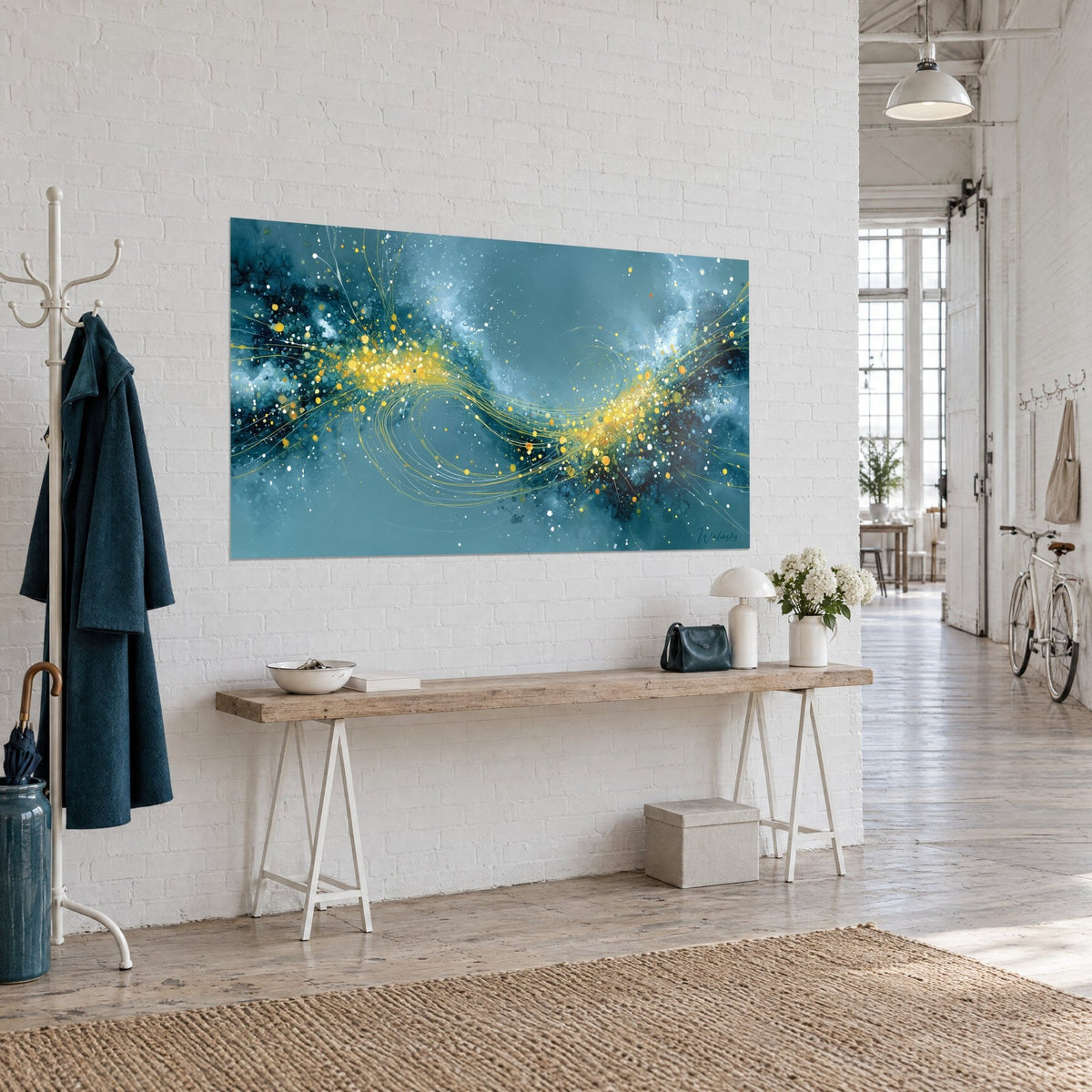 Tableau galaxie abstraite turquoise et or, sillage de gouttelettes dorées sur fond sombre, sur un mur blanc en vue de trois-quarts