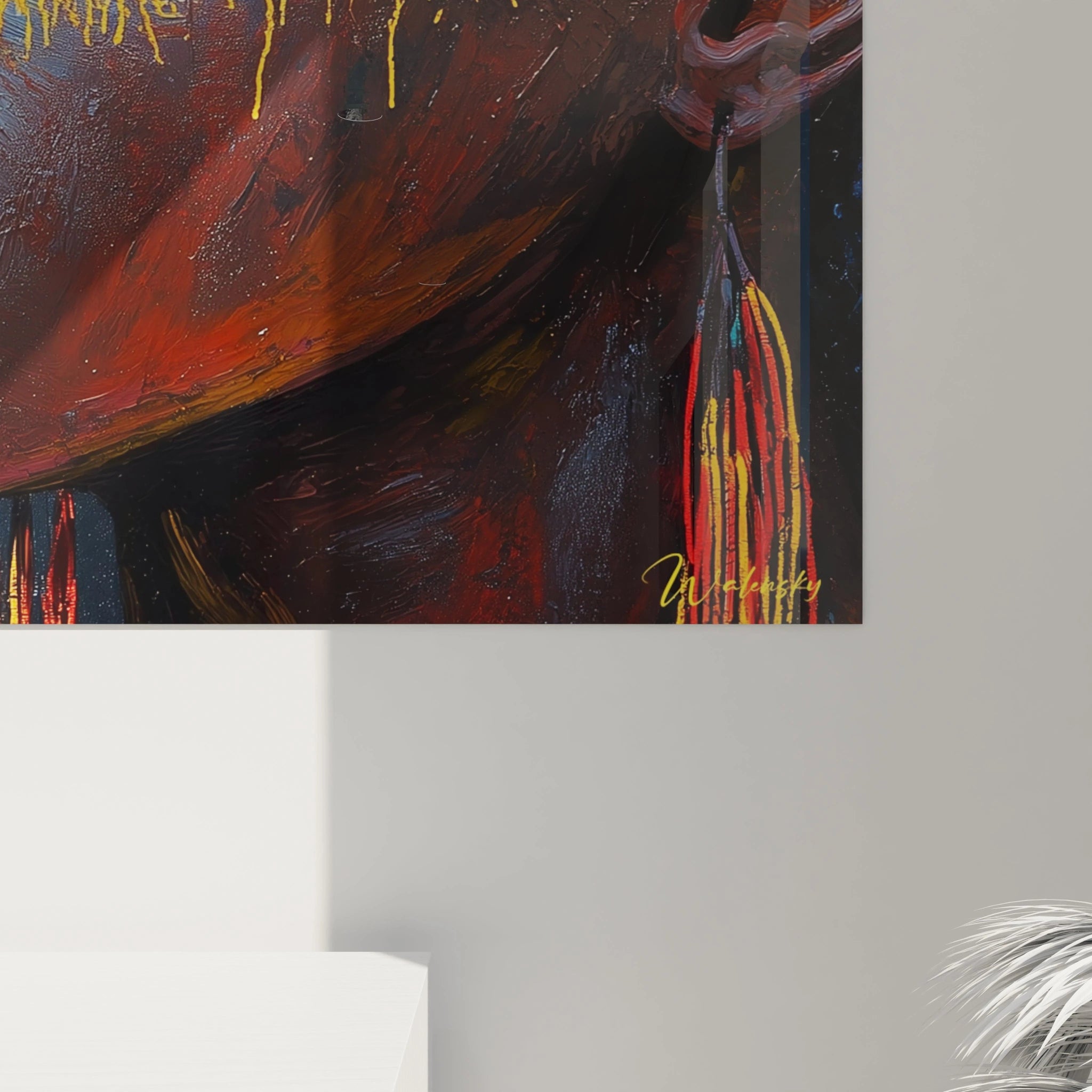 Détail d'un tableau africain mural Walensky avec peinture aux tons rouges, jaunes et noirs accroché sur un mur gris