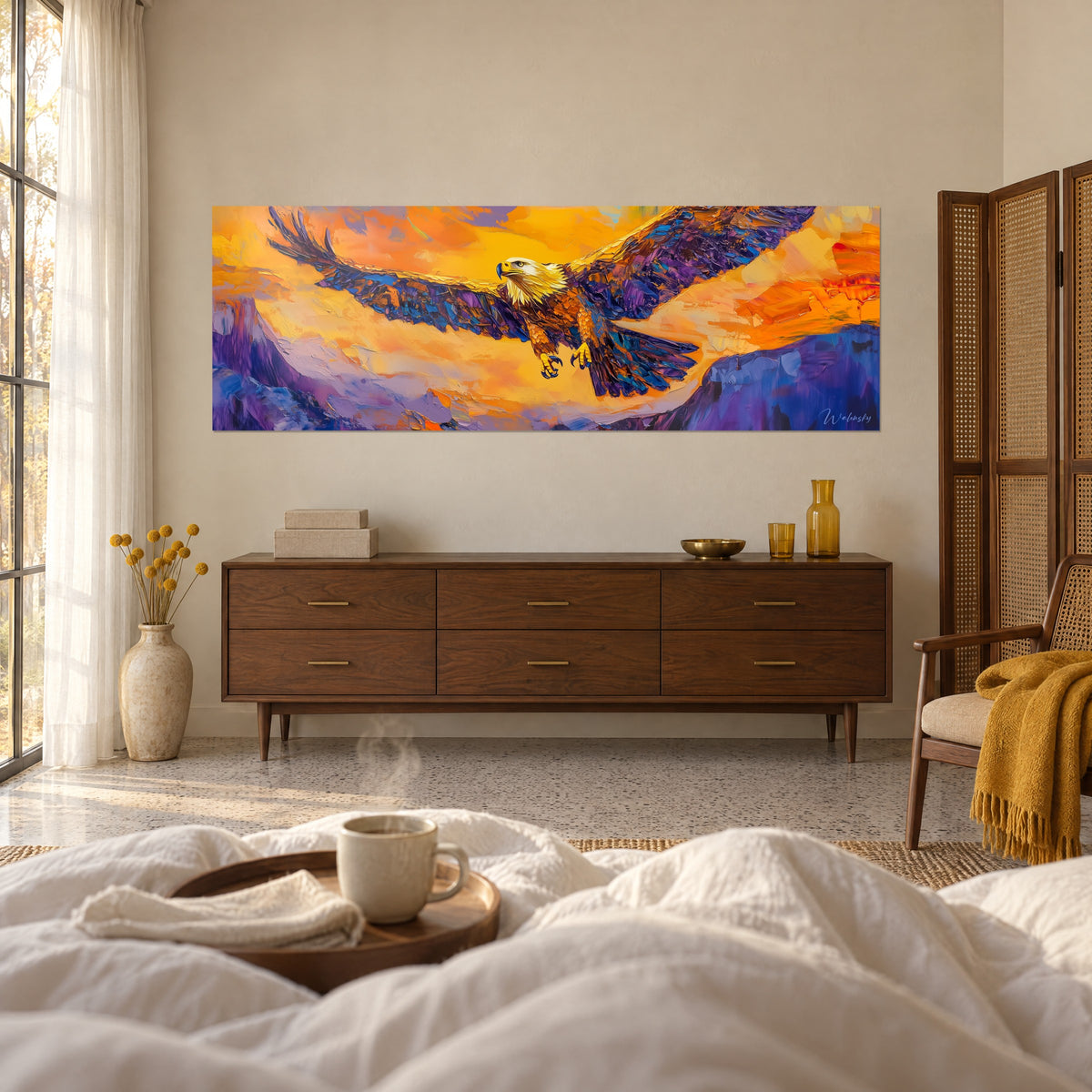 Cuadro águila calva planeando, alas azul noche y ocre, encima de una cama en un dormitorio luminoso