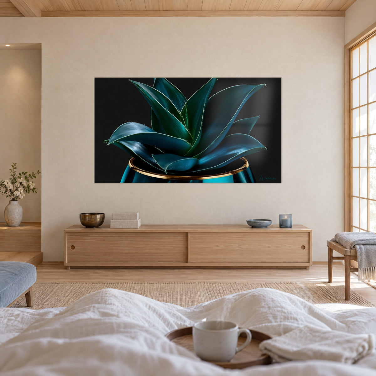 Wall art teal aloe vera rosette with pale spines, gold edging on black, a person seen from behind, above a bed in a bright bedroom