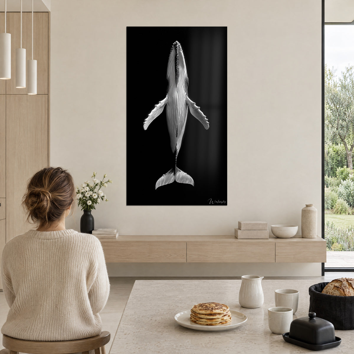Cuadro ballena jorobada con surcos nacarados, silueta blanca sobre fondo negro, frente a una mesa de desayuno junto a un ventanal